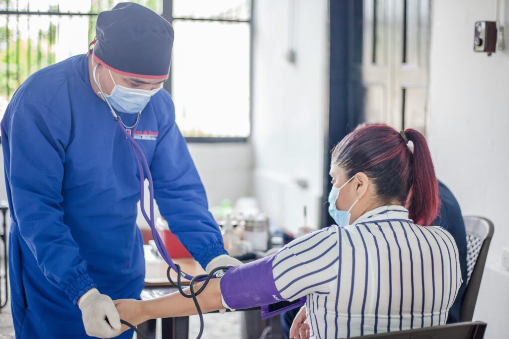 pexels photo 12193104 12193104 A nurse performs a blood pressure check on a patient in a healthcare setting, emphasizing safety and care.