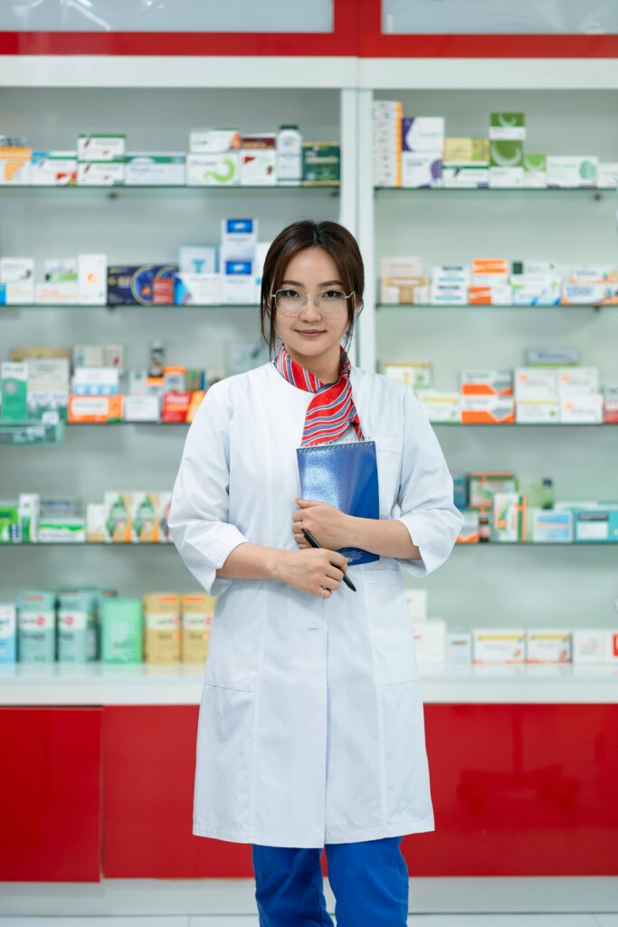pexels photo 19471013 19471013 Female pharmacist in a lab coat standing confidently in a well-organized pharmacy.